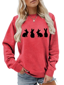 Detail of red crewneck sweatshirt featuring black rabbit silhouettes and ribbed cuffs