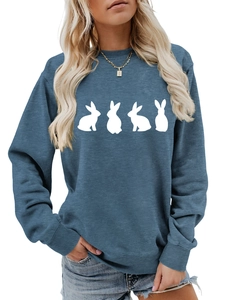 Detail of blue crewneck sweatshirt with white rabbit silhouettes in casual loose fit