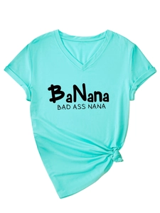 Détail du t-shirt col V vert menthe avec inscription 'BAD ASS NANA' et noeud latéral
