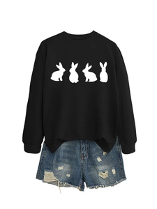 Flat lay of black crewneck sweatshirt with white rabbit prints and ripped denim shorts