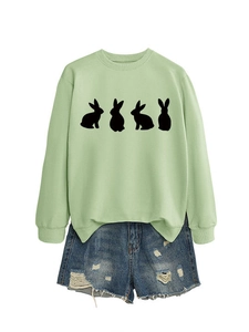Detail of sage green sweatshirt with black rabbit silhouette and ripped denim shorts