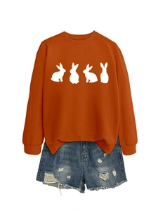 Detail of orange sweatshirt with white rabbit prints and distressed denim shorts