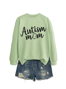 Flat lay of an Autism Mom light green sweatshirt with denim shorts on white background