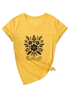 Détail du t-shirt jaune à col en V avec imprimé floral et nœud élégant sur l'ourlet