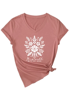 Gros plan du t-shirt col V vieux rose avec imprimé floral et citation It Is Well With My Soul