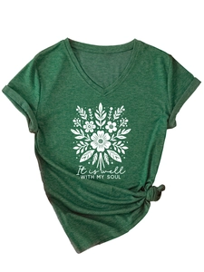 Détail d'un t-shirt col en V vert foncé avec imprimé floral et nœud latéral élégant