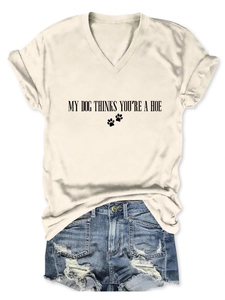 Détail du t-shirt col V blanc cassé avec empreintes de pattes et texte humoristique