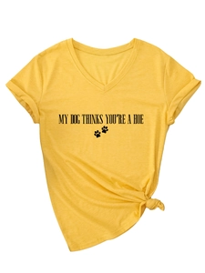 Détail du t-shirt jaune à col en V avec texte humoristique et nœud élégant sur le devant
