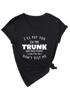 Close-up of white graphic text on black V-neck t-shirt with stylish knot at the hem