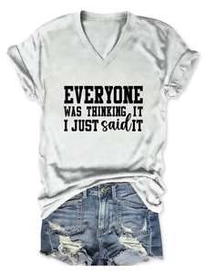 Détail du t-shirt blanc à col en V avec slogan et short en jean bleu délavé usé