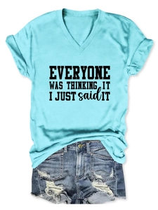 Détail d'un t-shirt bleu clair col en V avec texte imprimé et short en jean vieilli