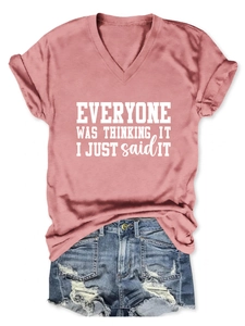 Détail d'un t-shirt rose à col en V avec slogan blanc et short en jean vieilli