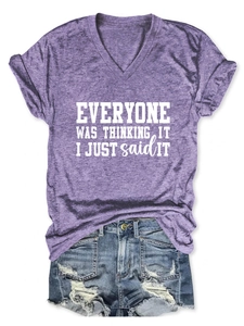 Détail du t-shirt violet à col en V avec slogan blanc et short en jean vieilli
