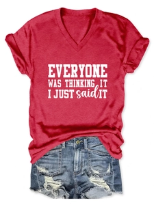 Détail d'un t-shirt rouge à col en V avec texte imprimé et short en jean bleu