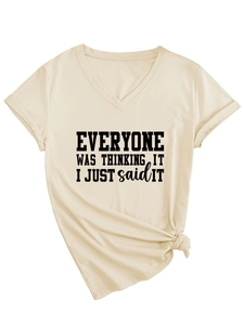 Détail d'un t-shirt beige à col en V avec slogan imprimé et nœud latéral à l'ourlet