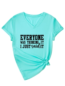 Détail d'un t-shirt turquoise à col en V avec imprimé noir et nœud décoratif à l'ourlet