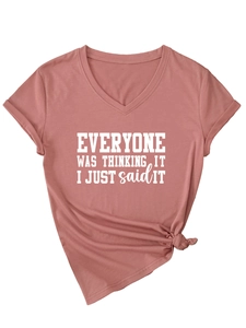 Détail d'un t-shirt à col en V rose poudré avec slogan imprimé et nœud latéral élégant