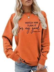 Detail of orange crewneck sweatshirt showing rib-knit cuffs and black religious text print