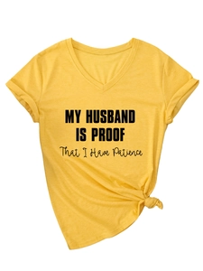 Detail of yellow V-neck t-shirt with My Husband Is Proof text and stylish knotted hem
