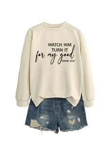 Flat lay of cream crewneck sweatshirt with biblical quote and ripped denim shorts
