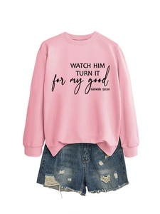 Detail of pink crewneck sweatshirt with slogan and distressed denim shorts outfit