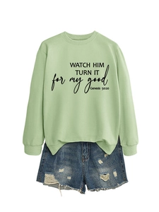 Flat lay of mint green crewneck sweatshirt and distressed blue denim shorts with print