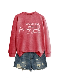Flat lay of red crewneck sweatshirt with white text and distressed denim shorts