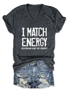 Flat lay of a grey V-neck T-shirt with 'I MATCH ENERGY' slogan and distressed denim shorts