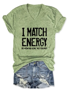 Olive green V-neck T-shirt with black text print paired with distressed denim shorts
