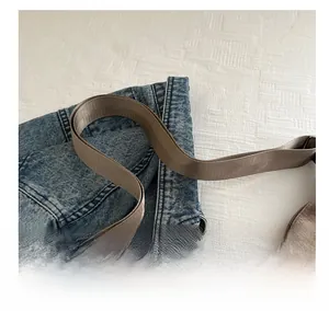 Detail shot of the durable thick nylon woven shoulder strap on a brown casual tote bag