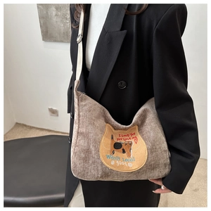 Detailed close-up of brown corduroy tote bag with cat embroidery and heart pattern