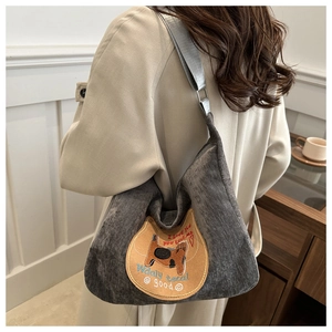 Detail of grey corduroy shoulder bag with yellow cat patch and heart embroidery