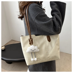 Große cremefarbene Leder-Tote-Bag mit braunen Riemen und Plüsch-Wolkenanhänger
