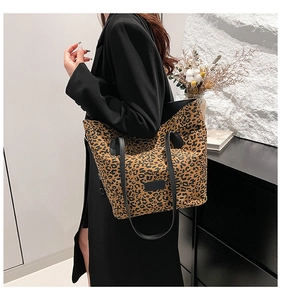 Close-up of leopard print tote bag with black straps on shoulder for casual styling