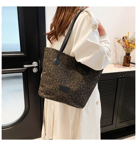 Detailed view of the leopard print tote bag with black slim straps on a model's shoulder