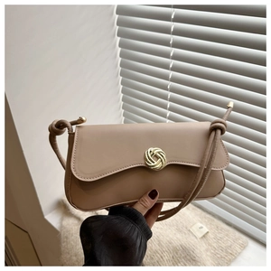 Detailed macro view of camel faux leather bag showing gold twisted metal lock closure