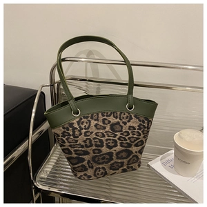 Detailansicht der Leoparden-Eimertasche mit grünen Kunstlederakzenten und silbernen Ringen