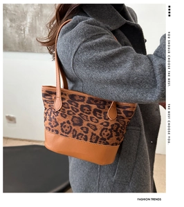 Vista laterale della borsa a spalla leopardata indossata sopra un cappotto di lana grigio
