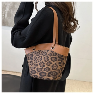 Nahaufnahme der Leoparden-Beuteltasche mit Lederbesatz getragen zu einem schwarzen Mantel