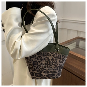 Detail der Leopardenmuster-Beuteltasche mit olivgrünen Lederriemen und Silberbeschlägen