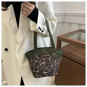 Details der Vintage-Eimertasche mit Leopardenmuster, dunkelgrünen Ledergriffen und Ringen