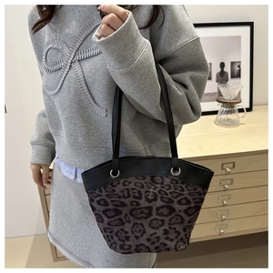 Detailaufnahme der Leoparden-Beuteltasche mit Ledergriffen und Metallbeschlägen