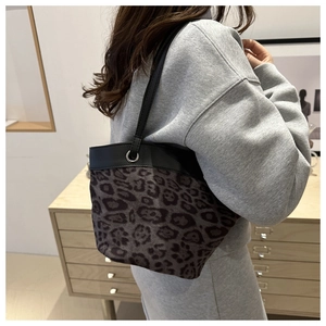 Detail der Beuteltasche mit Leopardenmuster und schwarzen Lederriemen an einem Modell