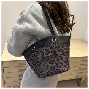 Leoparden-Eimertasche an der Schulter mit schwarzen Lederriemen und Tierfell-Textur