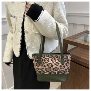 Dettaglio borsa shopper leopardata con finiture in pelle verde oliva indossata da modella
