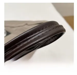 Macro detail of high-quality brown leather tote strap with reinforced double stitching