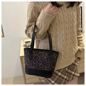 Dettaglio della borsa a tracolla leopardata alla moda con cinturini in pelle nera sul modello
