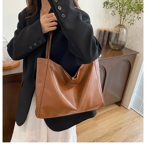 Detailed view of large caramel tote bag with magnetic closure and soft PU leather texture