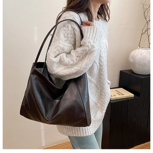 Minimalist large capacity dark brown leather tote bag for women shown as a shoulder bag