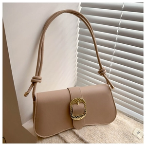 Close-up of light brown shoulder bag with gold square buckle and thick knotted strap detail